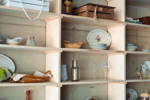 shelf with vintage dishes and other items in the dining room. photo