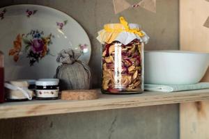 dried apples in a jar and jam on a shelf. Rustic food shelf photo