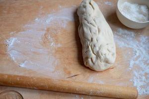 trabajando en una prueba de rodillo sin terminar. preparar pasteles de masa foto