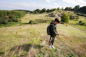Activity on sunny autumn day, boy exploring nature. Kid wear backpack hiking. photo