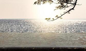 Stone shelf in the backdrop of sunset sea  Free space for product presentation photo