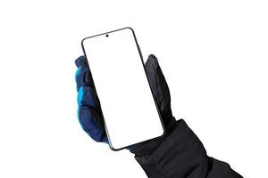 maqueta de invierno de un teléfono en una mano con un guante, para promover el diseño de aplicaciones o páginas web. de cerca foto