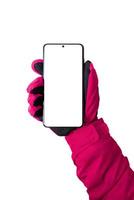 mano de mujer con guante sosteniendo un teléfono inteligente en posición vertical frontal. pantalla aislada y fondo para maqueta foto
