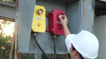 retrato de un ingeniero eléctrico asiático profesional que enciende los interruptores. video