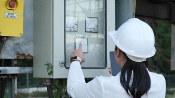 Electrician checking Analog voltmeter with dial and arrow. Engineer inspects the fire control panel to manage the factory outside. video