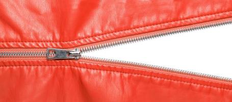 Red leather texture and open metal zipper isolated on white background photo