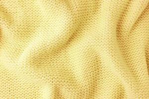 Pastel yellow knitwear wool fabric texture background. Abstract textile backdrop photo