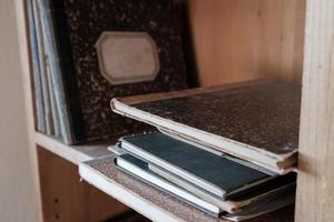 cuadernos de papel en tapa dura, apilados y de pie en un estante. de cerca. foto