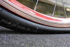 Punctured bicycle wheel, with a deflation tire on the pavement. Bike repair. Bottom view. photo