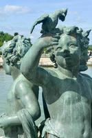 Statuette in the gardens of the famous Palace of Versailles in France photo