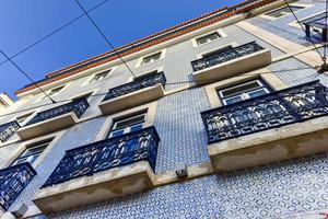 Lisbon windows with typical portuguese tiles on the wall photo