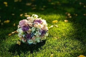 Delicate wedding bouquet lies on a background of green grass photo
