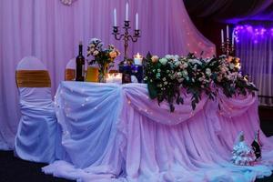 mesa de bodas en el restaurante con composición floral foto