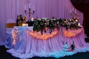 hermoso restaurante de bodas para matrimonio. decoración blanca para la novia y el novio. decoración colorida para la celebración. belleza interior nupcial. ramo, comida y flores en el pasillo foto