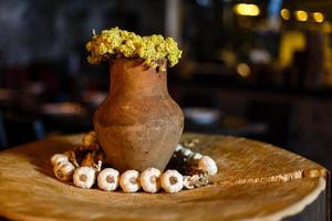decor, clay pot with yellow flowers stands on a stump photo