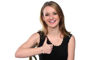 Portrait of young beautiful woman peeping at the camera showing thumbs up. isolated on white photo