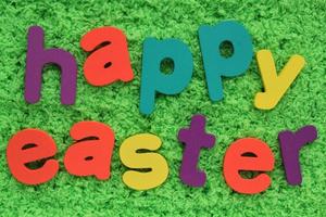 Happy Easter colored lettering on green grass background. Holiday spring composition concept. Creative idea for greeting card, poster, banner, invitation, web. Top view, flat lay, close up photo