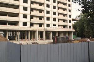 Windows of building on new residential area construction site fence. Industry modern civil house business. Concept of development improvement town. Architecture planning of a city. Renovation project. photo