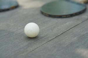 bucles de tenis de mesa y raqueta en mesa de madera foto