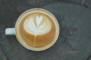 café caliente en forma de flor colocado sobre una mesa de madera foto