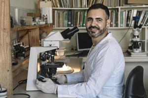 Scientist examining samples under a microscope. photo