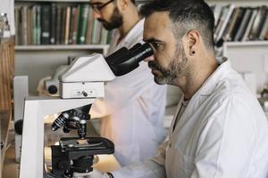 científico analizando muestras bajo el microscopio. laboratorio científico. foto