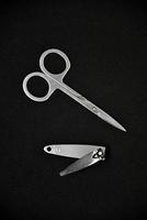 Manicure set on a black background. Scissors and nail tongs. Iron scissors and nail clippers. photo