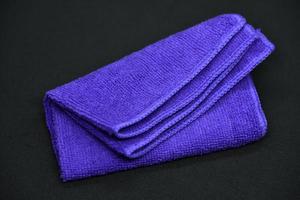 A cloth for wiping. Purple cloth on a black background. Towel. photo