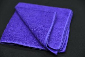 A cloth for wiping. Purple cloth on a black background. Towel. photo
