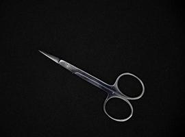 Manicure set on a black background. Scissors and nail tongs. Iron scissors and nail clippers. photo