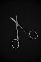 Manicure set on a black background. Scissors and nail tongs. Iron scissors and nail clippers. photo