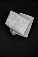 Three gray towels on a black background. Terry cloths for wiping furniture. Towels on a black background. photo