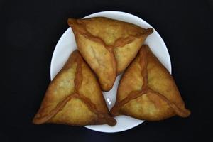 empanadas de carne en un plato blanco. Belyashi deliciosos pasteles de carne sobre un fondo negro. foto