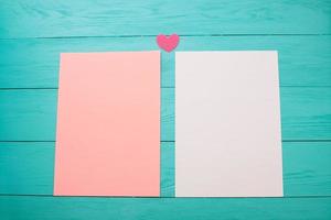 hojas de papel en blanco de color vacías sobre una mesa de madera de cerca foto