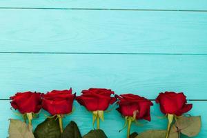 Frame of colorful roses on blue wooden background. Top view and selective focus. Mock up. Copy space. Flowers. Mother Valentine photo
