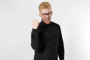 campeón, concepto de ganador de la vida. joven emprendedor exitoso con fuertes ambiciones, pasión por ser el número uno. hombre guapo con pelirroja, barba roja con gafas elegantes. la camisa negra. copie el espacio peinado foto