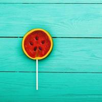 Watermelon summer candy food on blue wooden background. Top view. Mock up. Copy space. Sweet Lollipop photo