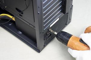 el técnico está apretando los tornillos de la computadora, fijando la computadora foto