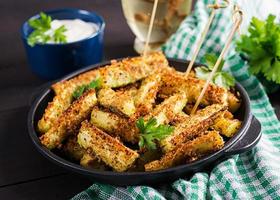 Palitos de calabacín al horno con queso y pan rallado. comida vegana. cocina vegetariana foto