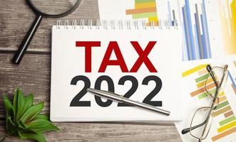 impuesto 2022, sistema tributario. palabra en cuaderno blanco y gráficos