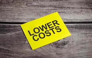 lOWER COSTS Text on business paper on office table photo