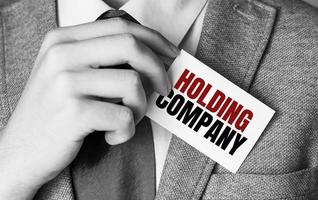 holding company words on business card and hand photo