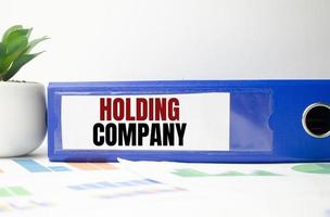 holding company words on blue paper folder and charts photo