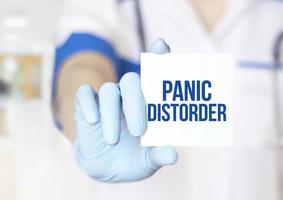 palabras de trastorno de pánico en la pegatina amarilla y la mano del médico