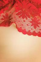 Lace knitted red fabric on a beige background. Checkered red tablecloth. photo