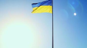 Slow-Motion-Flagge der Ukraine weht im Wind vor einem wolkenlosen Himmel bei Tagesanbruch. Das ukrainische Nationalsymbol des Landes ist blau und gelb. Flaggenschlaufe mit detaillierter Stoffstruktur. video