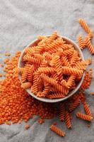 Fusilli red lentil pasta on a gray textile background. photo