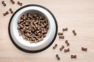 un plato de comida para perros en un piso de madera. foto