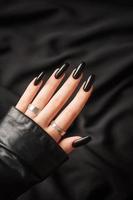 Hands of a young girl with black  manicure on nails photo