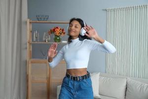 feliz mujer afroamericana con auriculares bailando. imagen borrosa y desenfocada. actividades de ocio foto